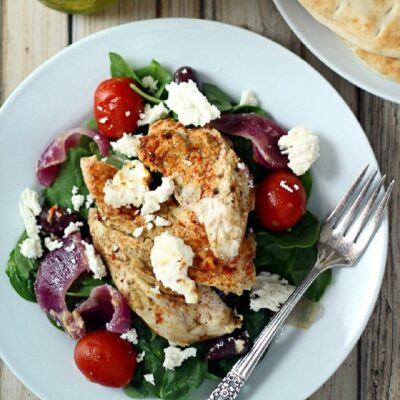 Plate with baked Greek chicken and pita breads on a plate.
