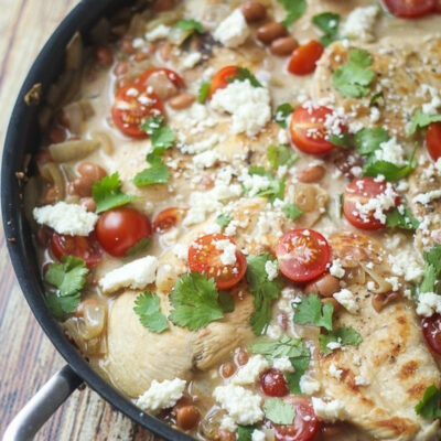 Mexican Chicken Skillet topped with fresh tomatoes, cilantro, and crumbled cheese.