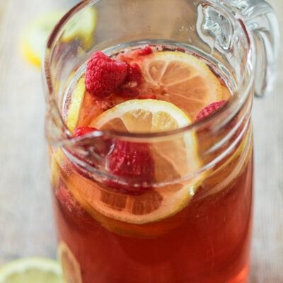 A glass pitcher containing raspberry sangria.