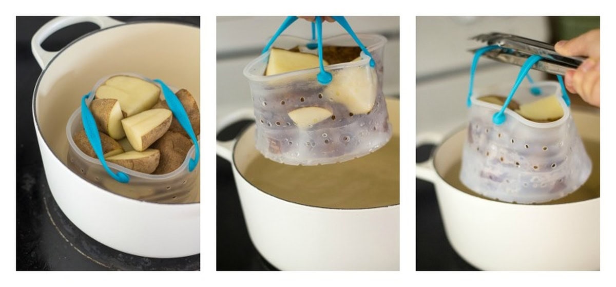 Potatoes placed in a perforated silicone basket being lifted from a pot of boiling water.