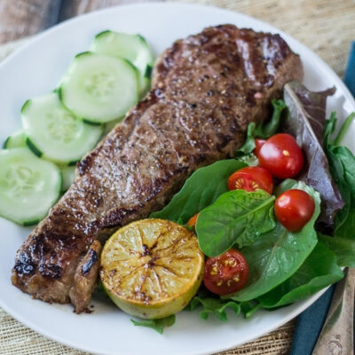 Grilled Vietnamese steak on a white plate.
