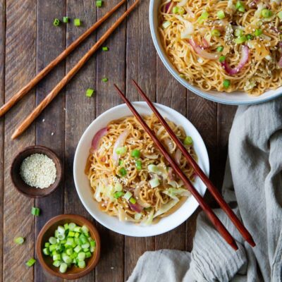 Two bowls with Yakisoba noodles on a table.