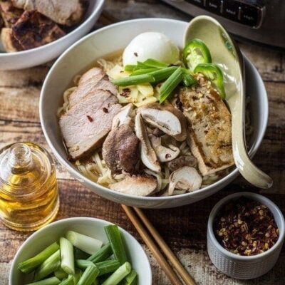 A bowl with ramen broth with different toppings.
