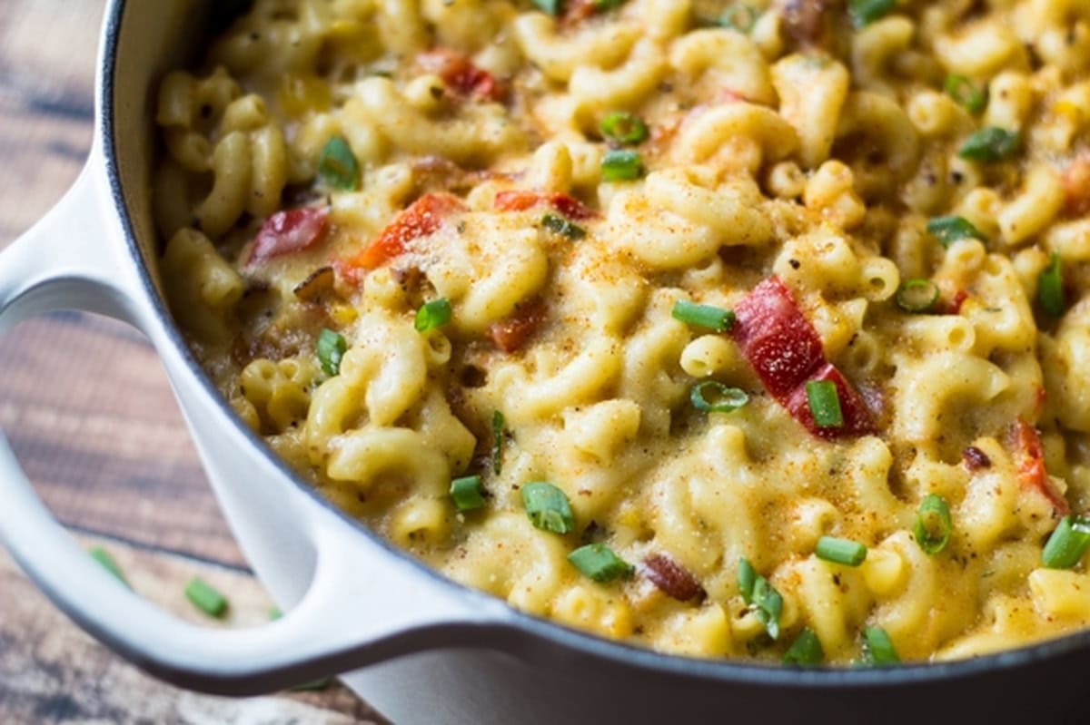 Cajun bacon mac and cheese in a white pot.