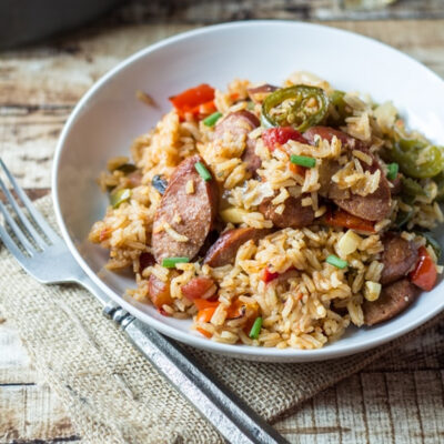 A plate with spicy sausage and rice.