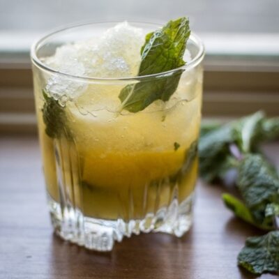A glass of Whiskey Smash on a table.