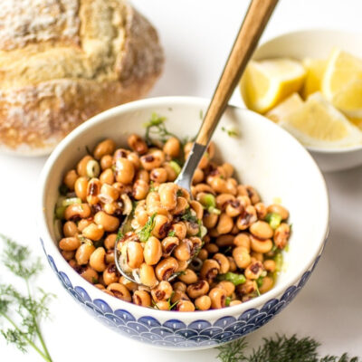 A bowl with Greek black eyed peas and a spoon.