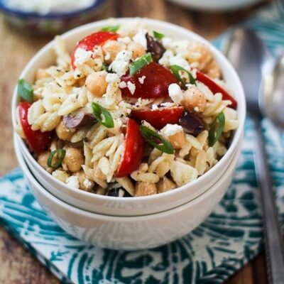 Mediterranean Orzo Pasta Salad in a white bowl on a table.
