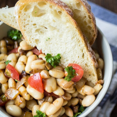 Tuscan White Bean Salad in a bowl served with bread.