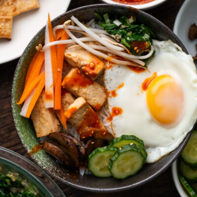 Pan-fried tofu is my protein of choice for this Vegetarian Bibimbap Recipe. Topped with seasoned vegetables, a dippy fried egg, and flavorful gochujang sauce, you don't have to be a vegetarian to enjoy this recipe!