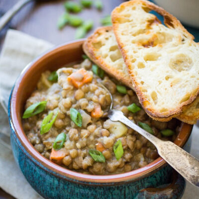 Vegan Lentil Soup in a bowl, served with crusty bread.