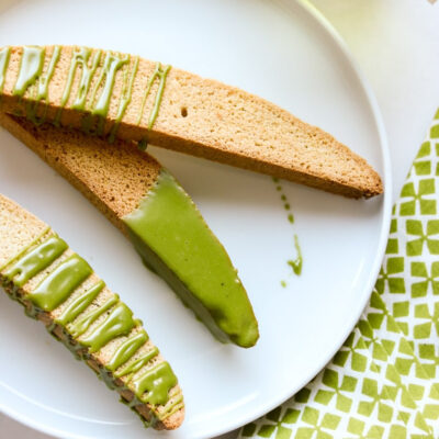 A plate with biscotti, drizzled with matcha.