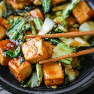 Bok choy in a bowl with chopsticks.