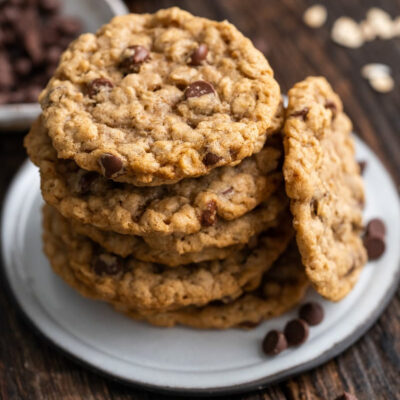 A stack of vegan oatmeal chocolate chip cookies on a white plate.