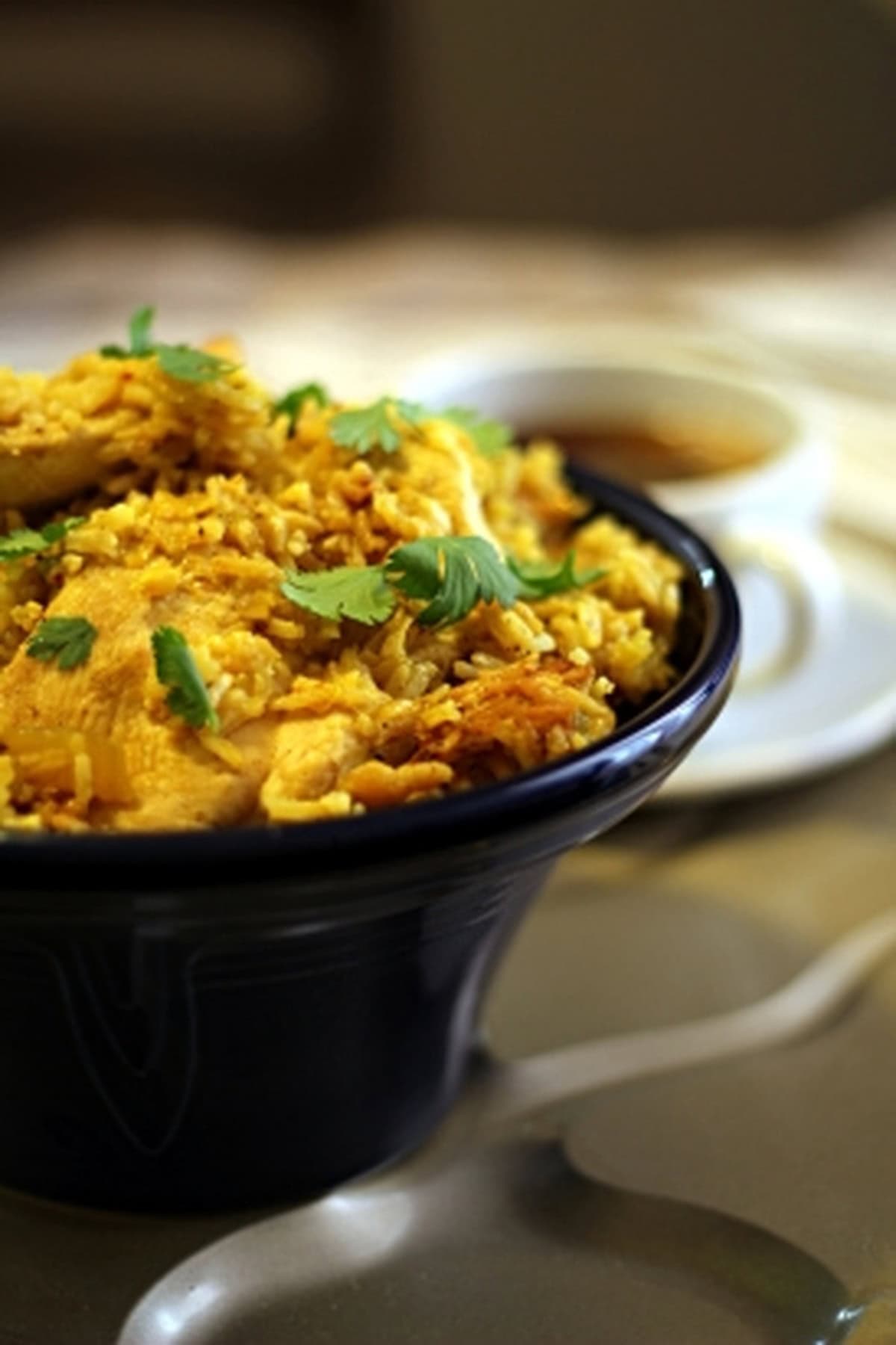 Thai garlic chicken and rice dish in a dark bowl.