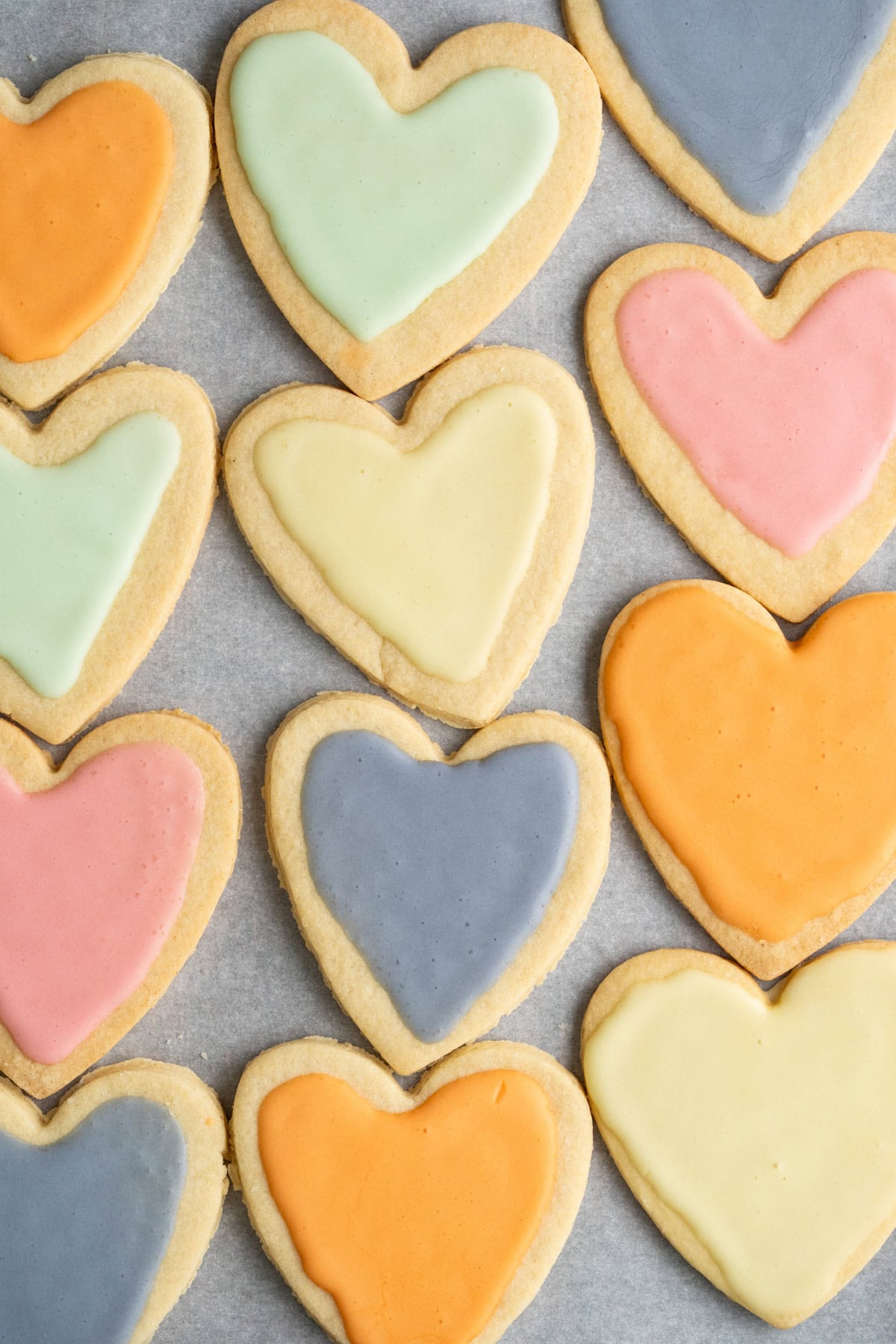 Colorful heart cookies on a piece of parchment paper.