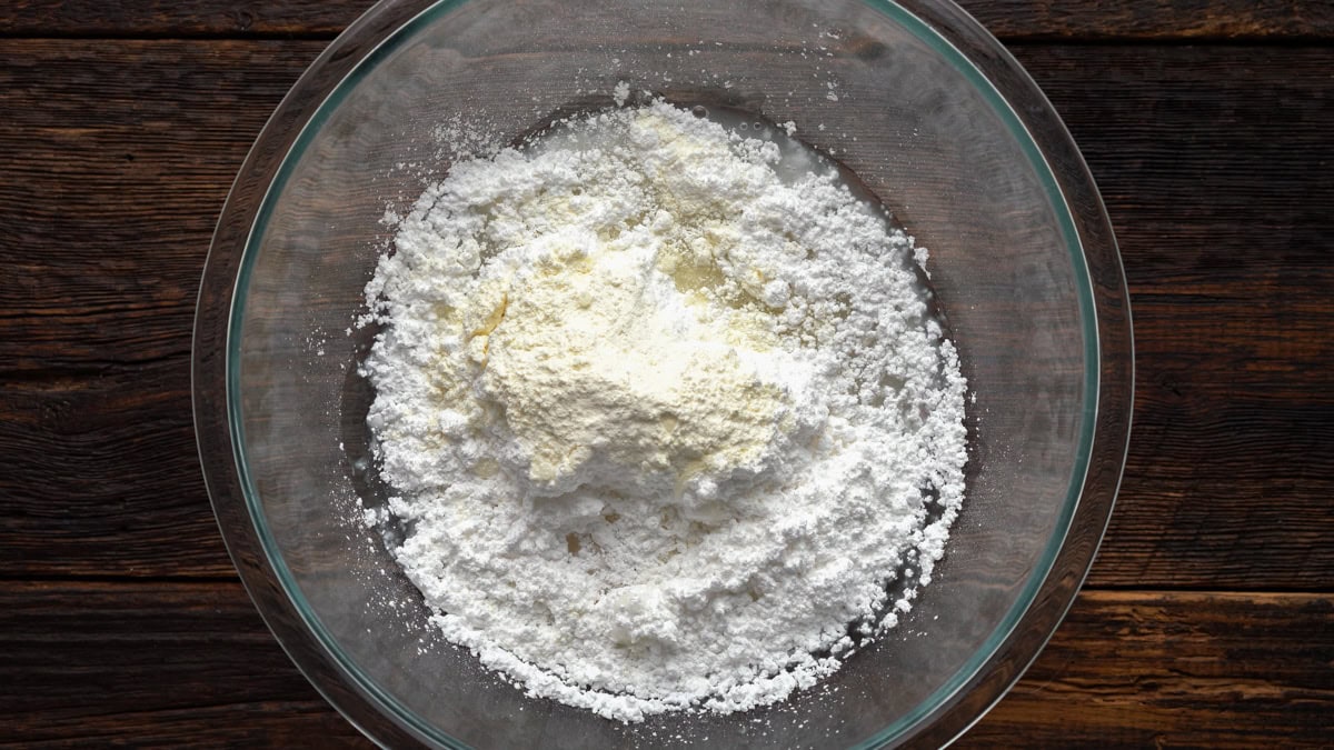 Ingredients for royal icing in a glass bowl.