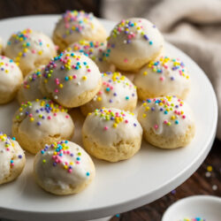 Indulge in these delicate Italian Easter Cookies. Soft, almond flavored cookies dipped in a sweet glaze and topped with colorful sprinkles.