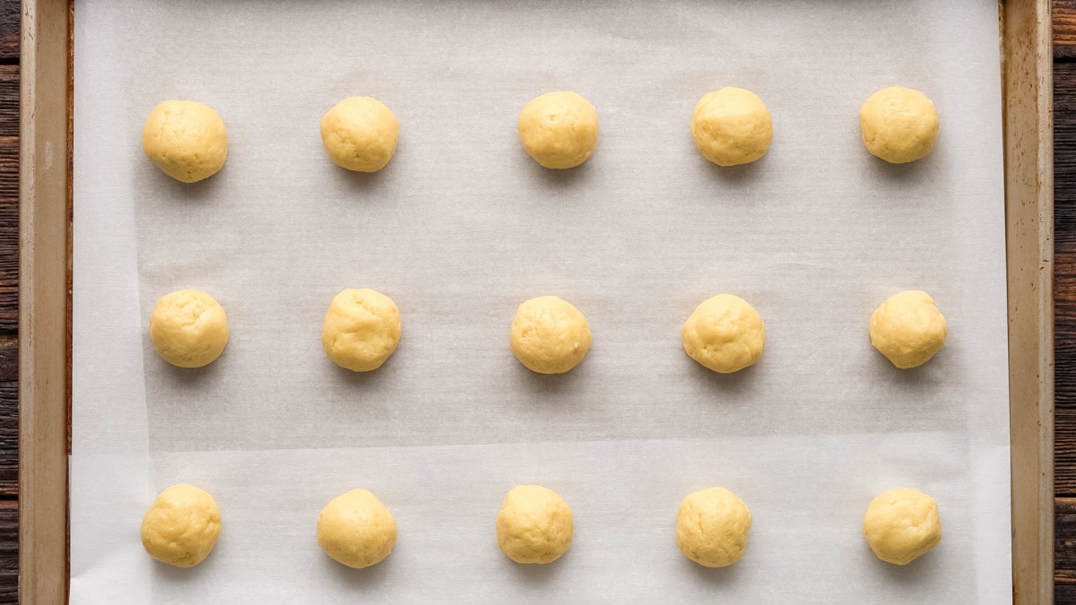Cookie dough balls on a baking sheet.