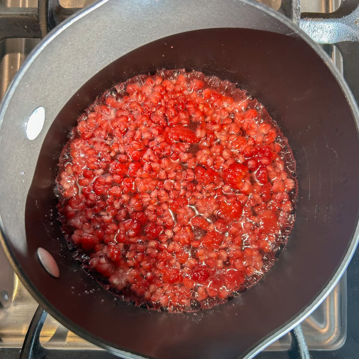 Raspberry simple syrup cooking in a pot.