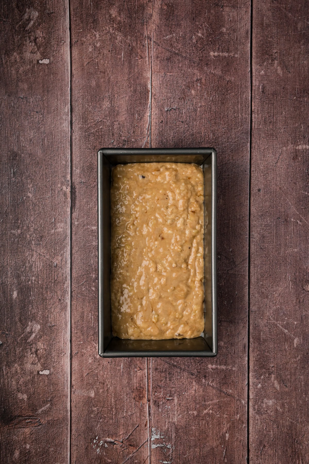 Banana bread batter in a loaf pan.