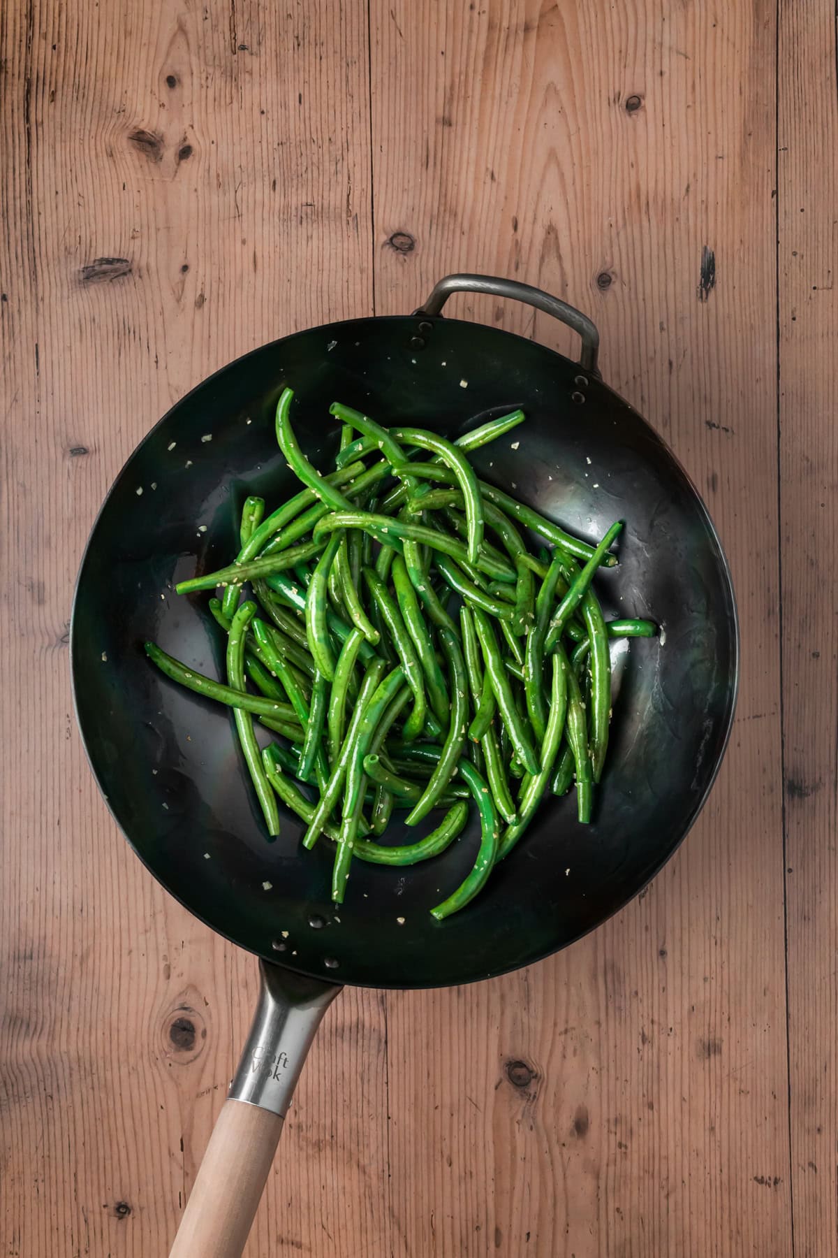Green beans added into the wok.
