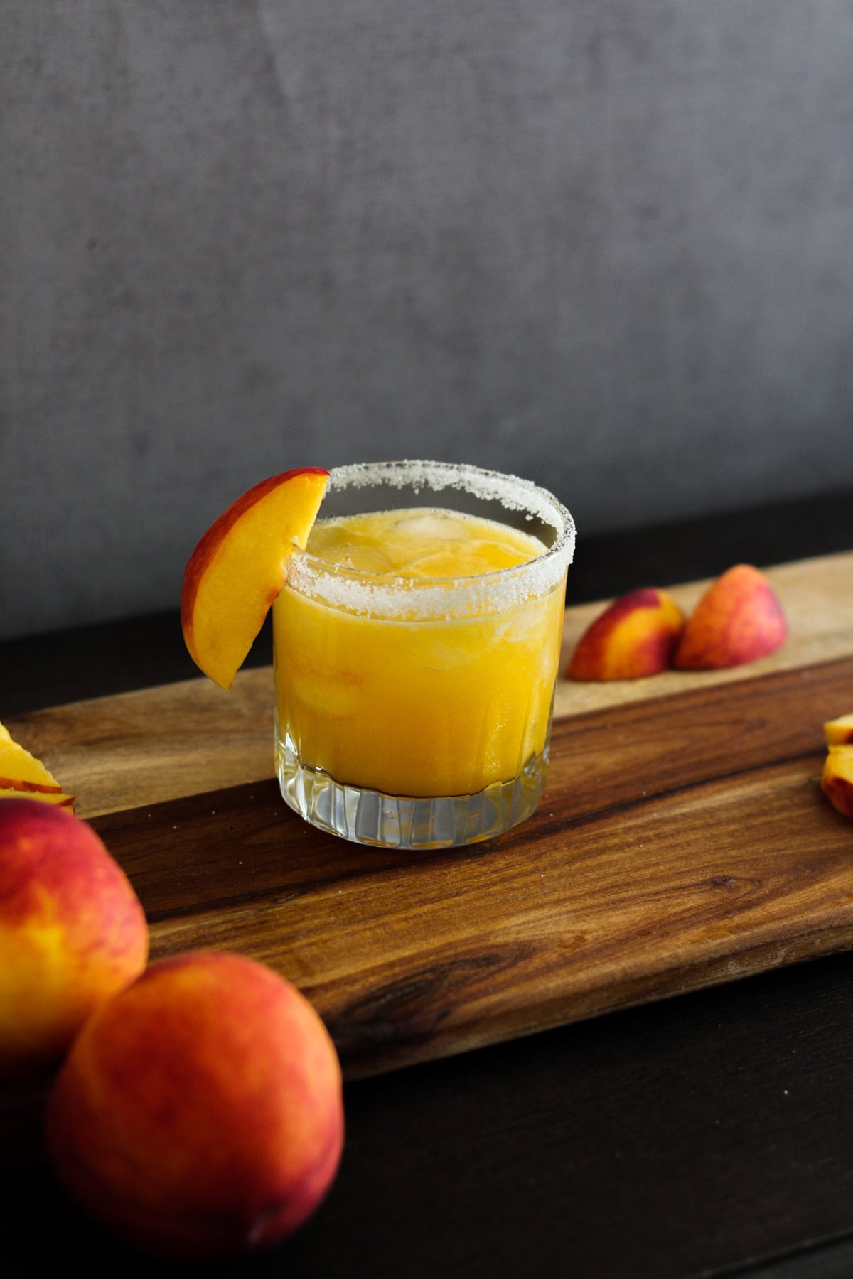 Peach margarita on a wooden board.