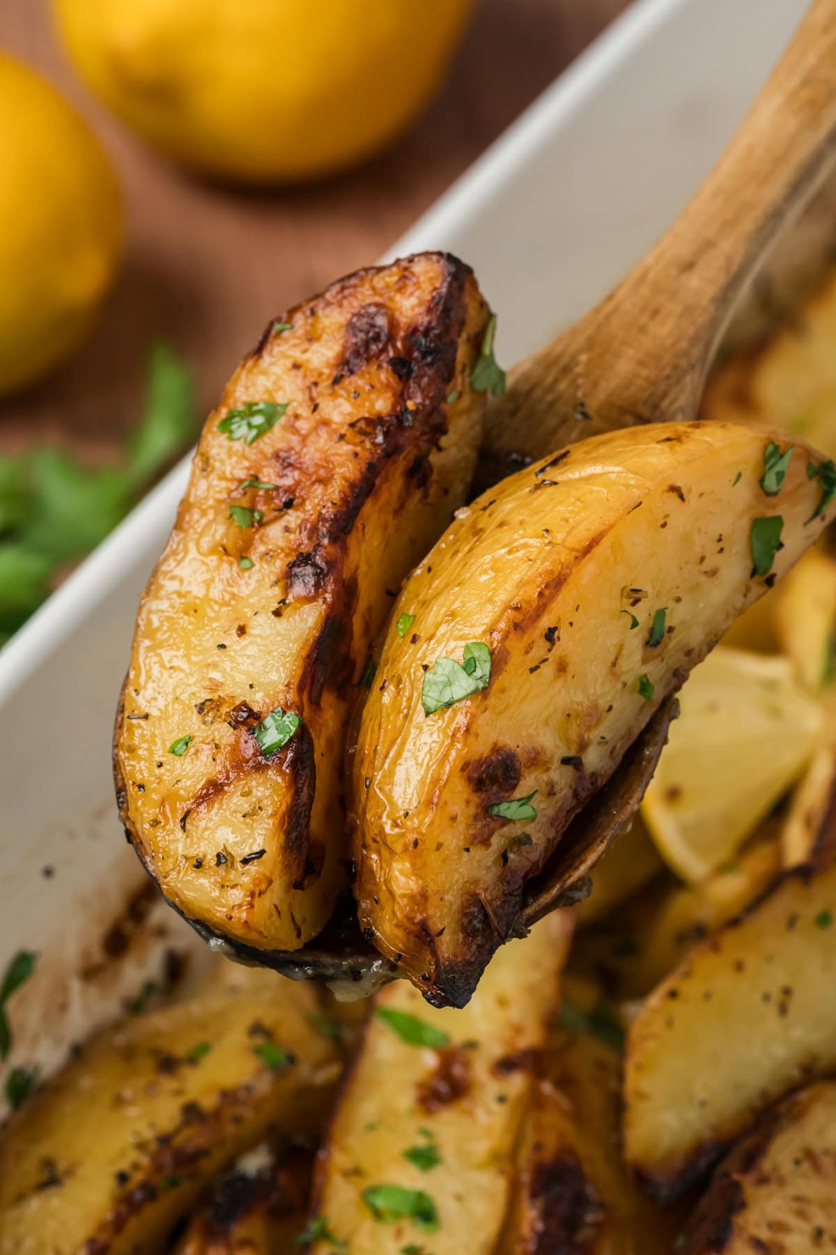 Wooden spoon full of Greek Lemon Potatoes.