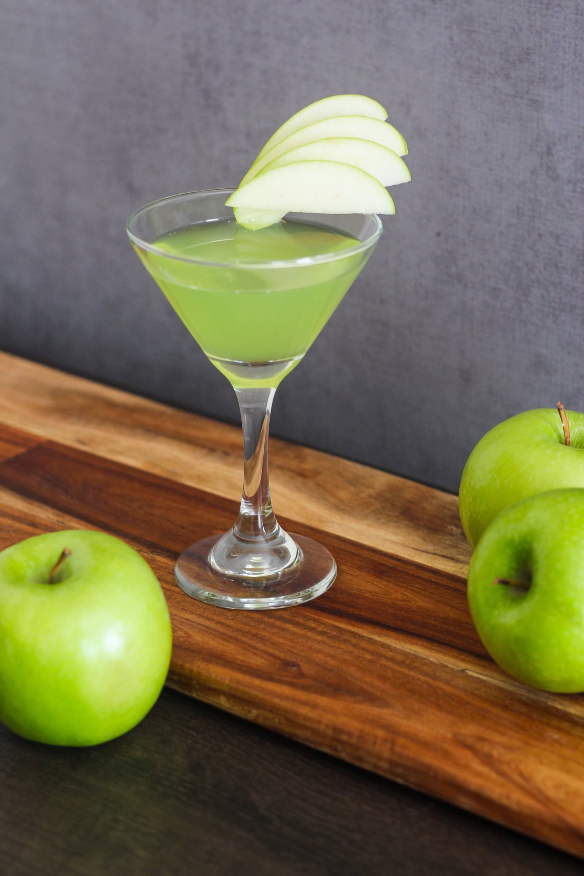 Appletini with slices of green apple as a garnish.