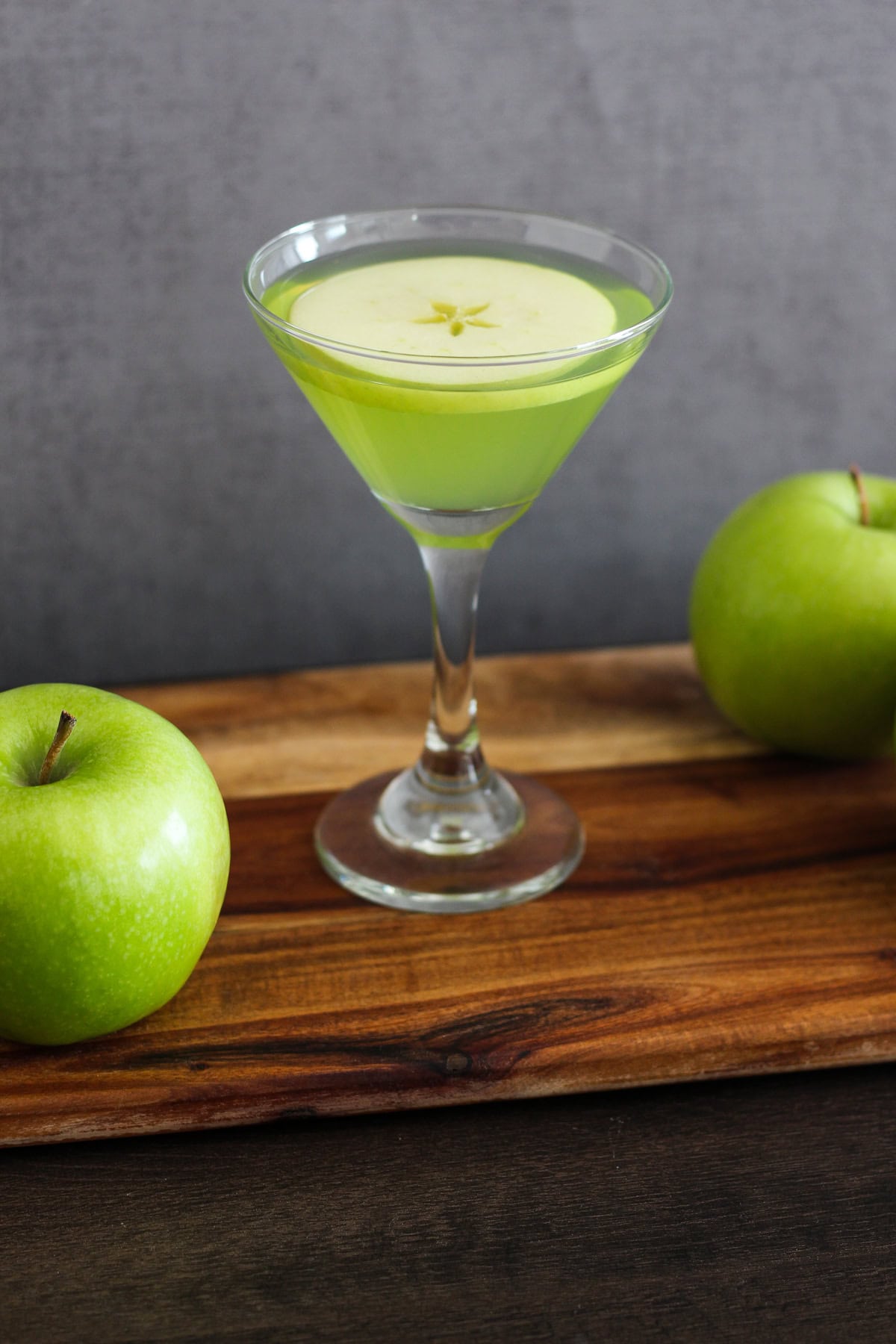Appletini with an apple round as a garnish.