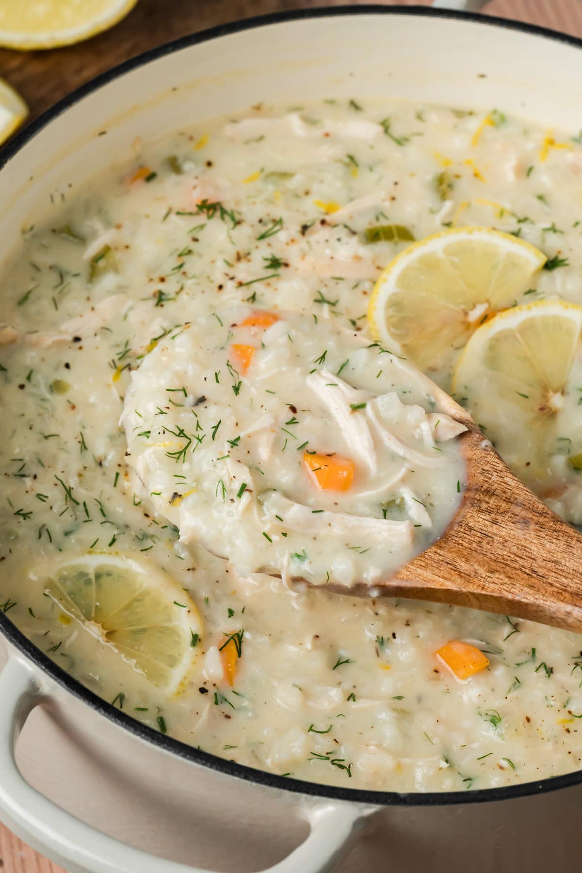 Wooden spoon of Avgolemono Soup coming out of the Dutch oven.