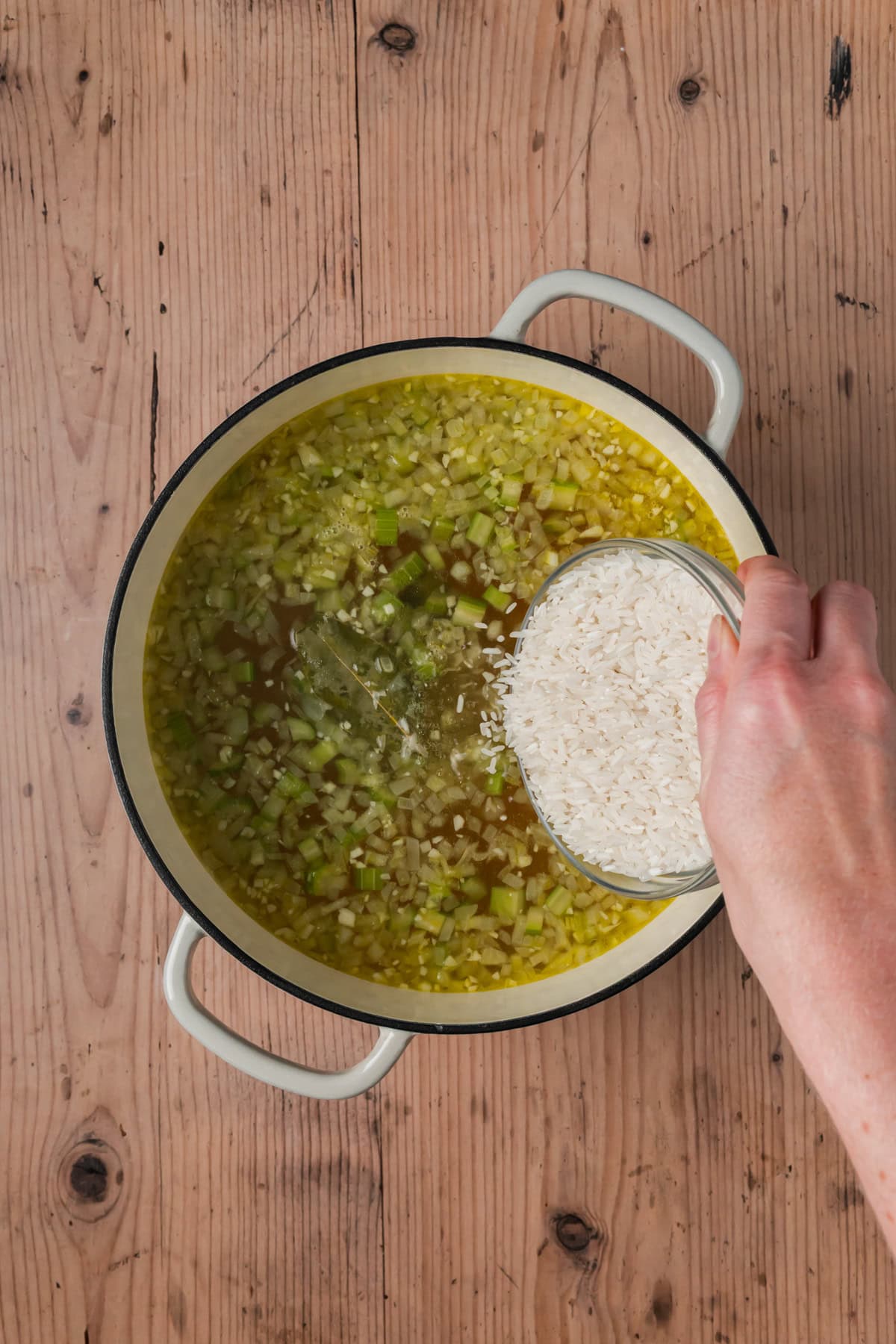 Rice being poured into the soup.
