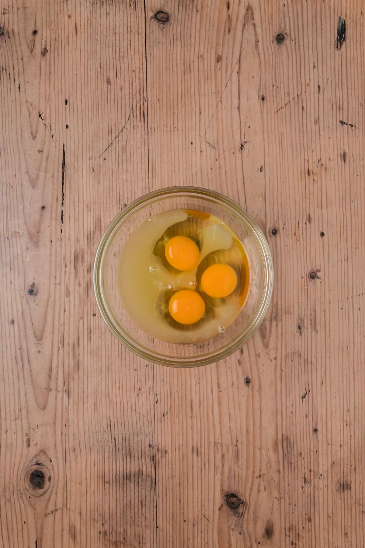 Eggs and lemon juice in a small glass bowl.