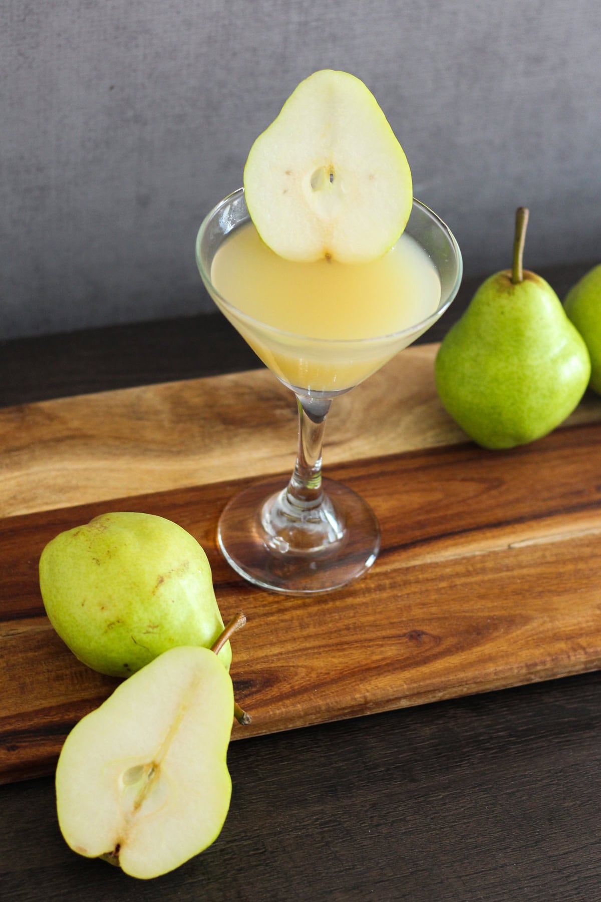 Pear martini with a slice of pear on the side.