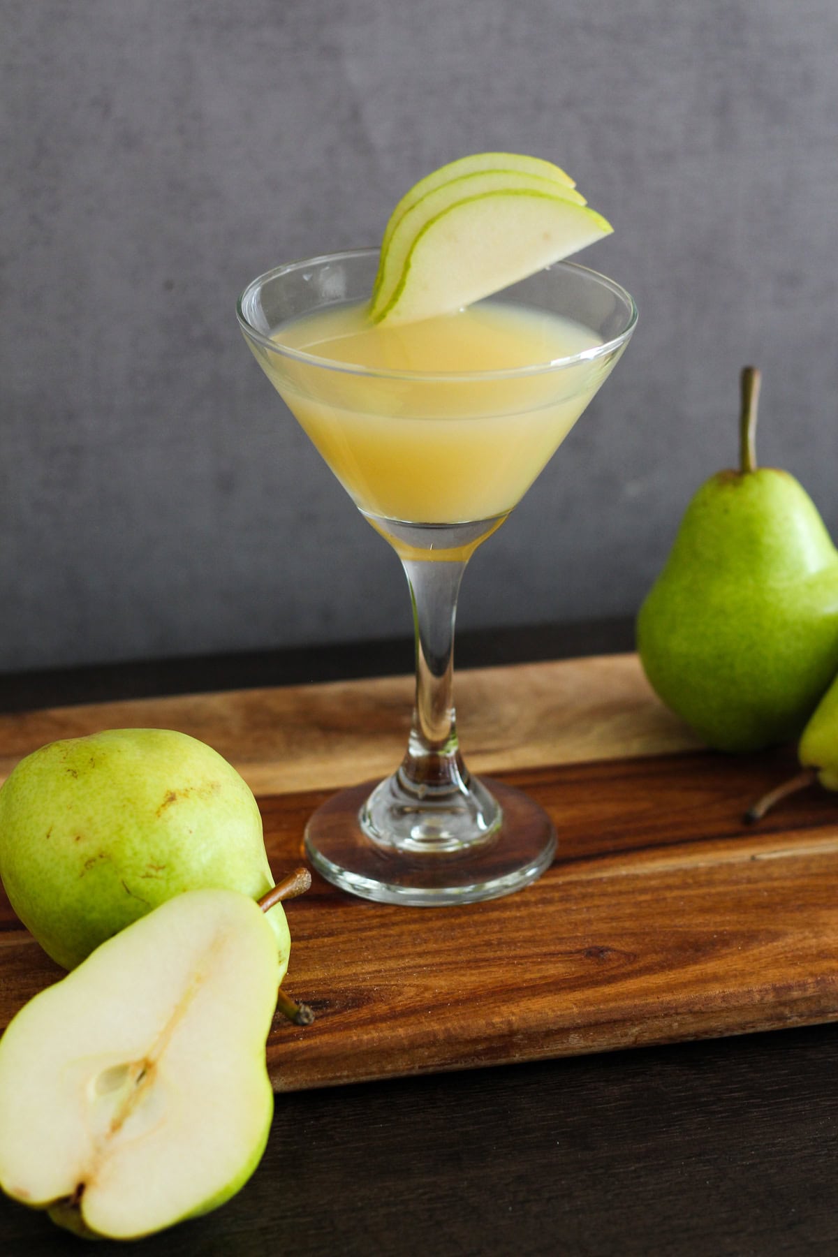 Pear martini with pear slices on the side.