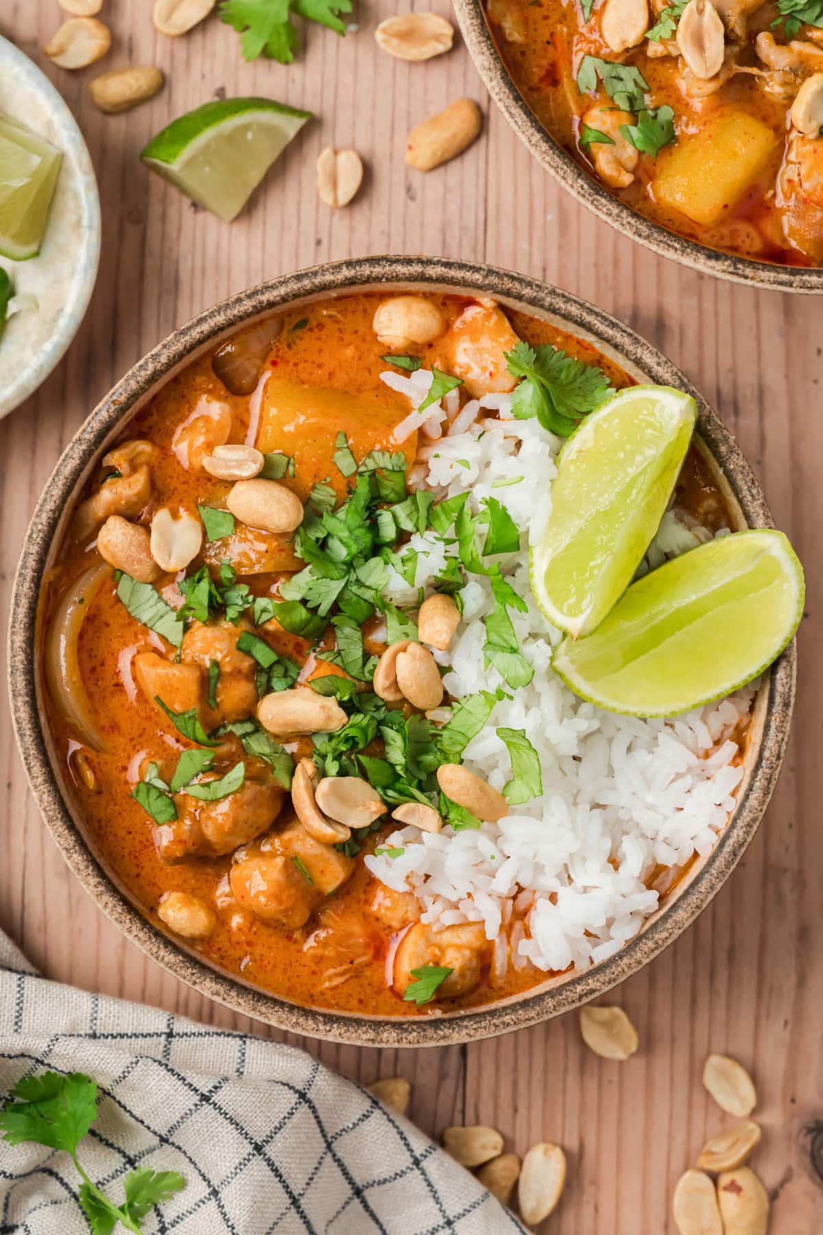 Massaman curry served with white rice and lemon wedges.