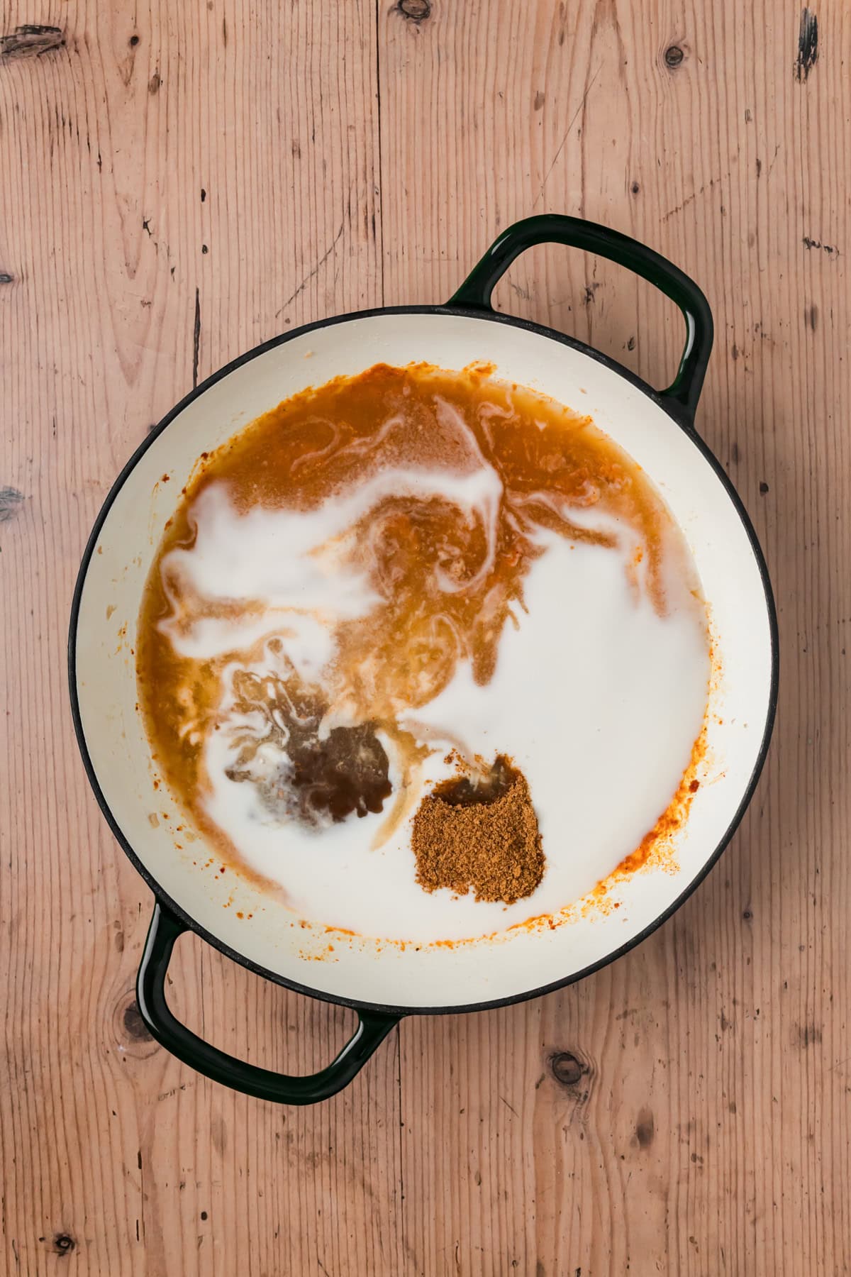 Coconut milk, chicken stock, fish sauce, tamarind, and coconut sugar added into the pot.