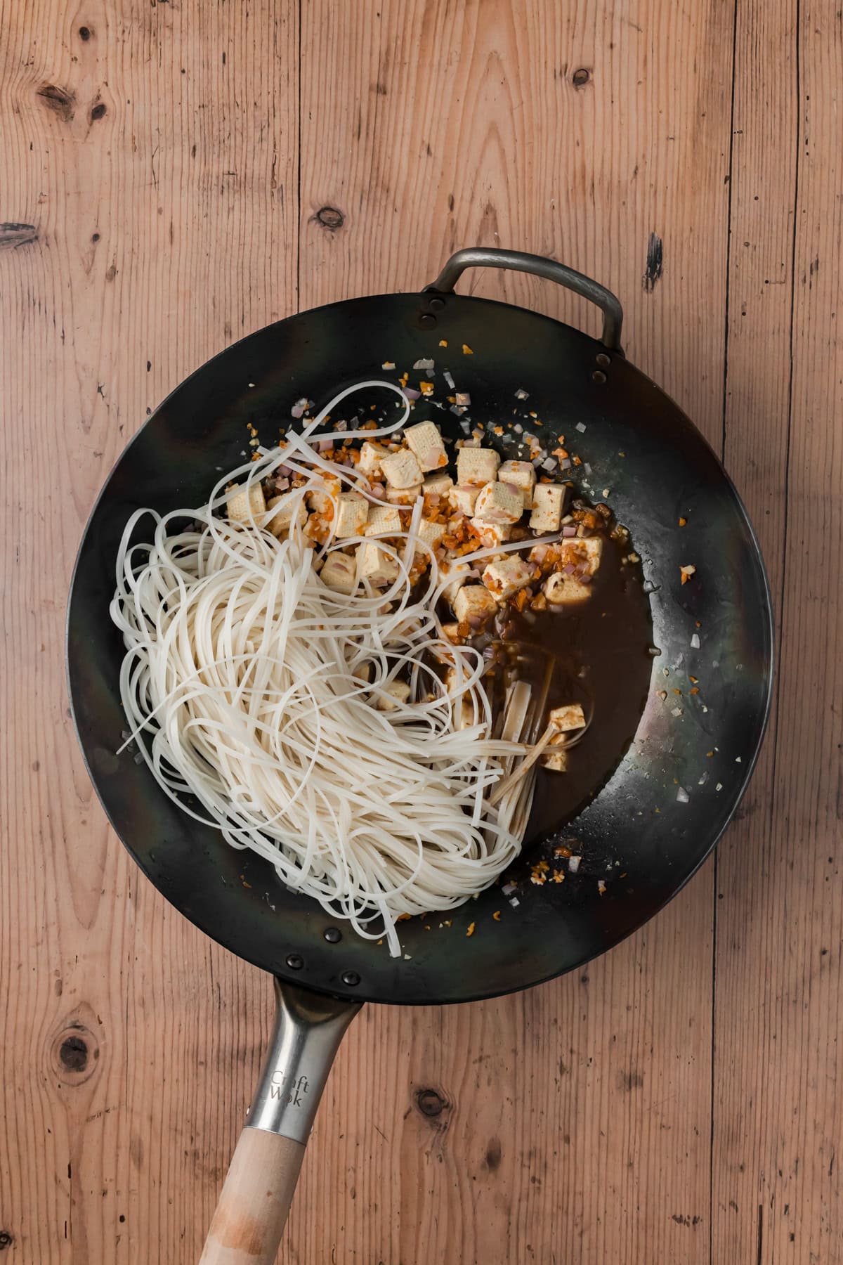 Noodles and sauce added into the wok.