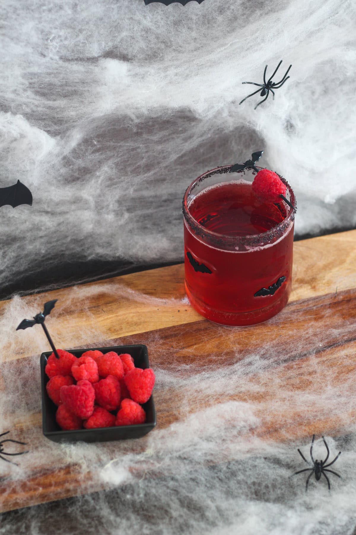 Vampire's Kiss Cocktail with raspberries on the side.