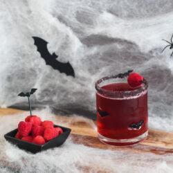 Vampire's Kiss Cocktail with raspberries on the side.