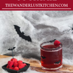 Vampire's Kiss Cocktail with raspberries on the side.