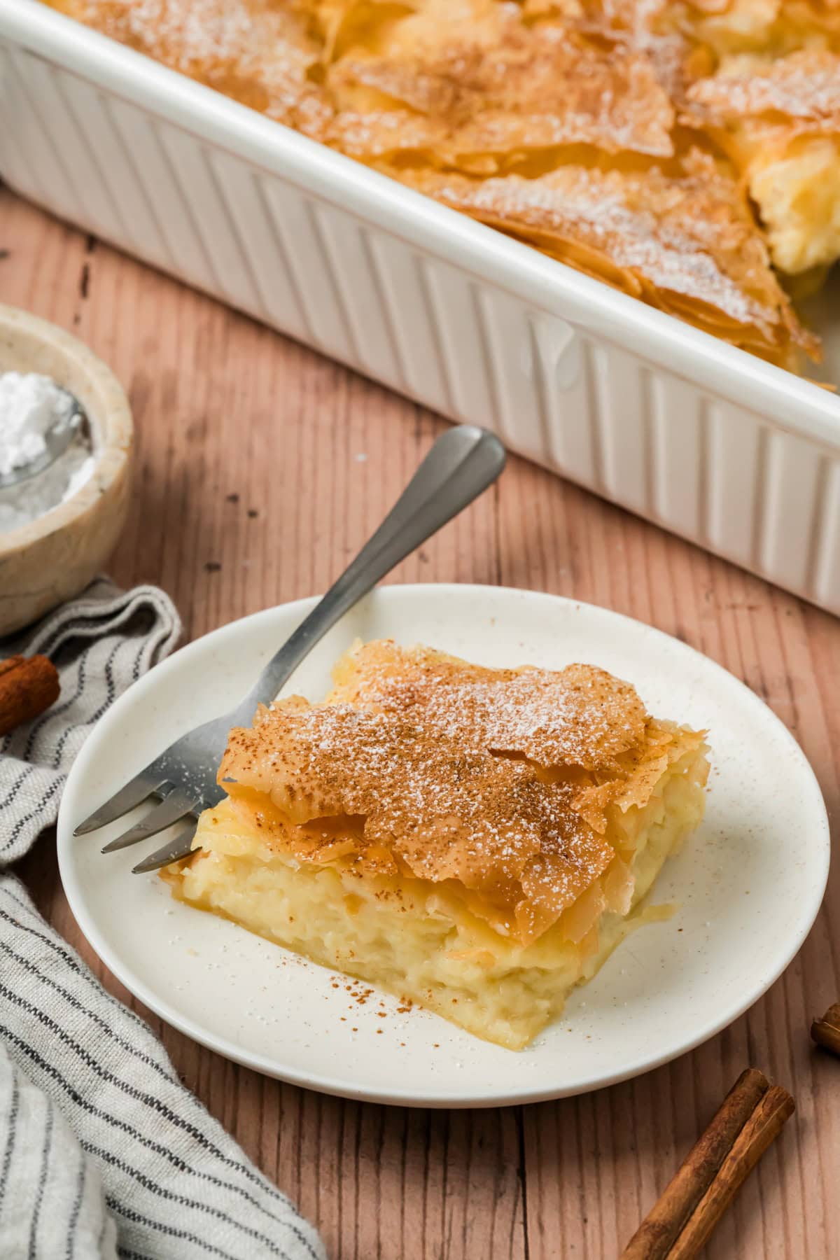A slice of bougatsa on a white plate.