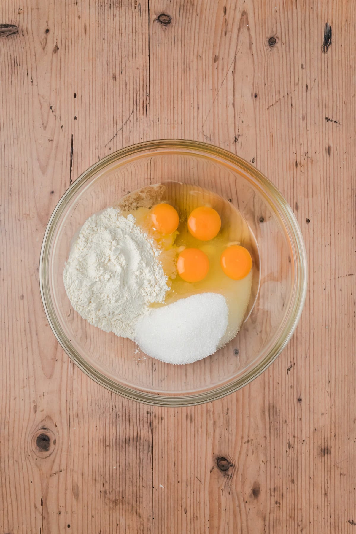 Flour, sugar, and eggs in a glass bowl