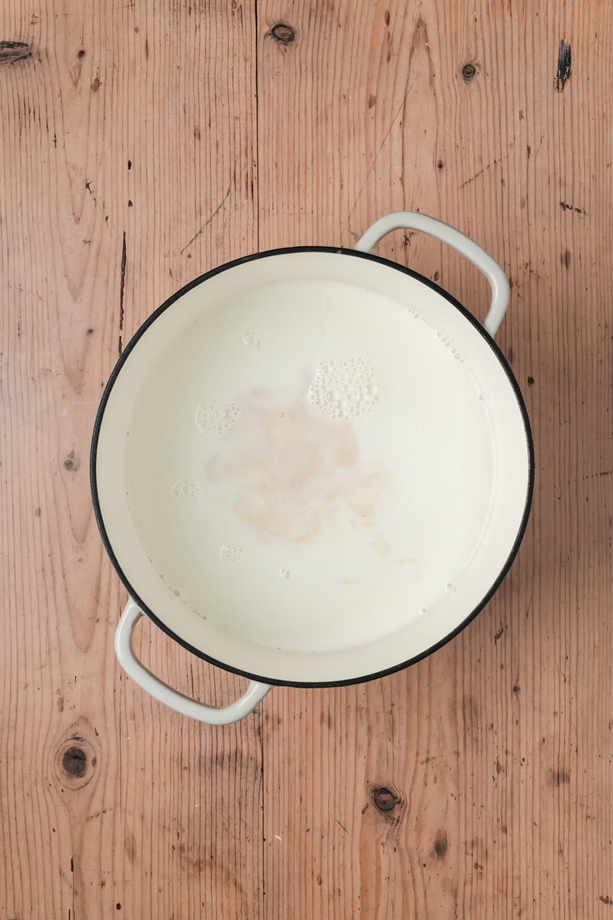 Milk and vanilla in a pot cooking.