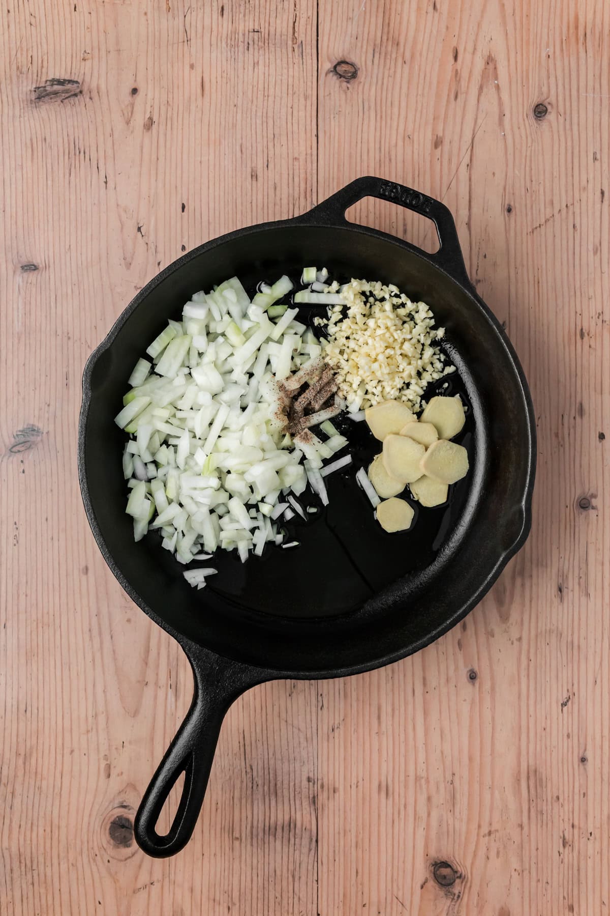 Garlic, ginger, cardamom, and onions in a skillet. 