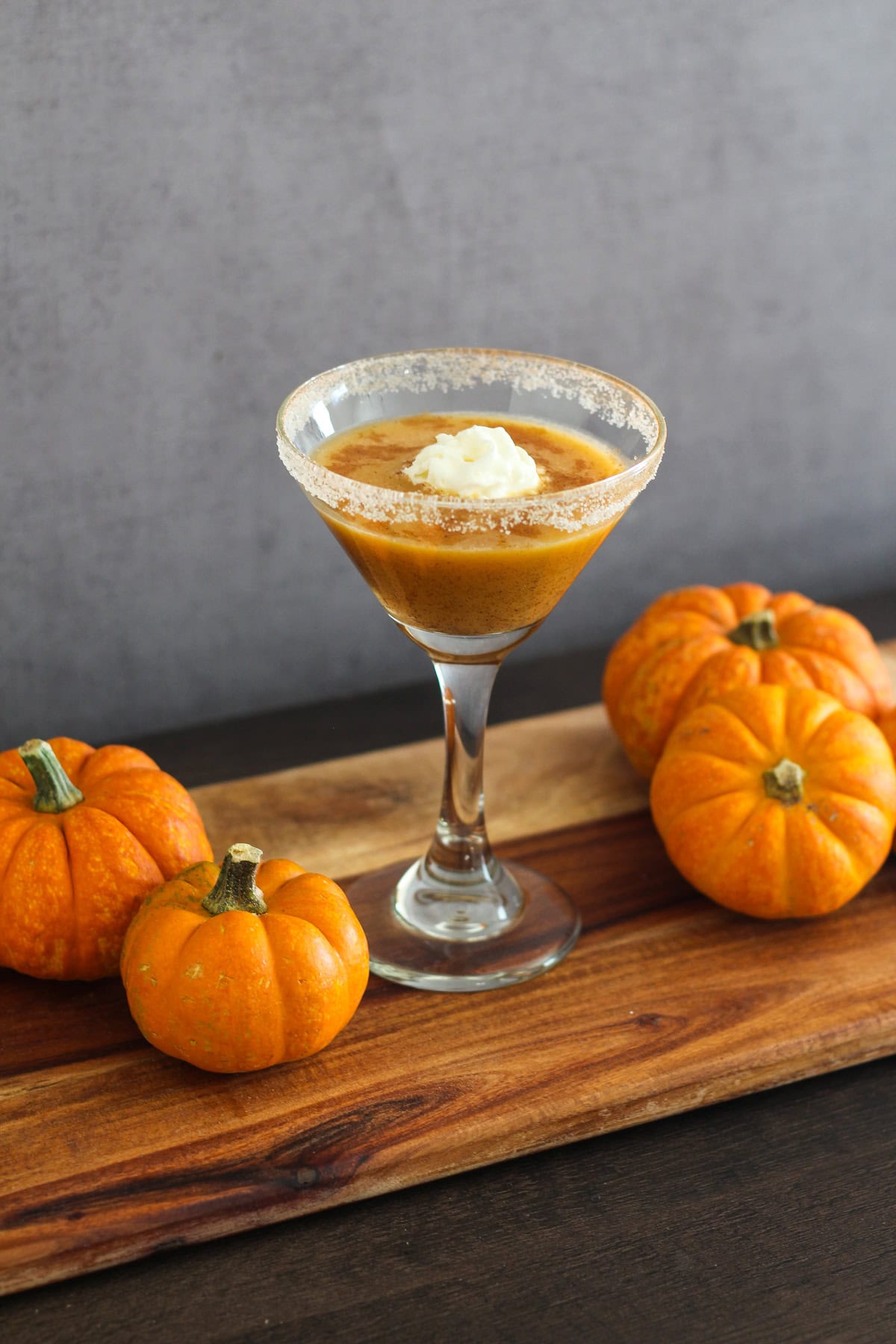 Pumpkin martini in a martini glass rimmed with sugar and pumpkin pie spice. 